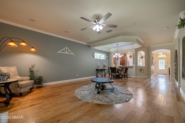 sitting room with ceiling fan with notable chandelier, light wood-type flooring, and ornamental molding