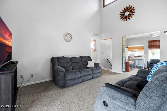 carpeted living room featuring a towering ceiling