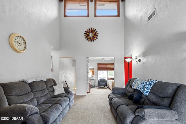 carpeted living room featuring a towering ceiling