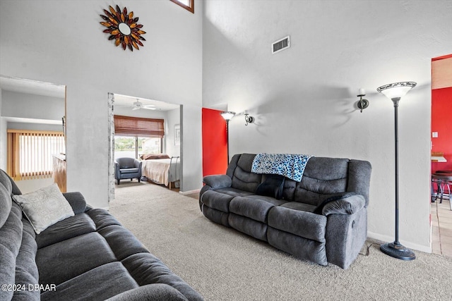 carpeted living room featuring high vaulted ceiling and ceiling fan