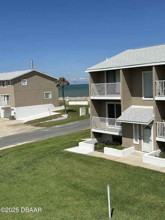 view of property's community with a water view and a lawn