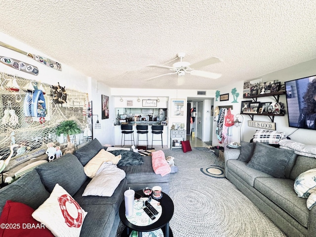 living room featuring a textured ceiling and ceiling fan