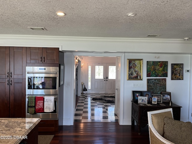 220 John Anderson Dr, Ormond Beach, FL 32176 - kitchen featuring stainless steel double oven, a textured ceiling, ornamental molding, dark wood-style floors, and dark brown cabinetry