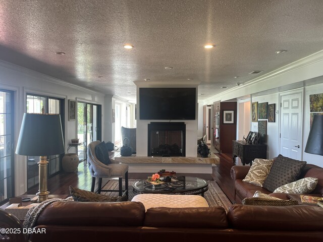 220 John Anderson Dr, Ormond Beach, FL 32176 - living area with wood finished floors, a textured ceiling, ornamental molding, a glass covered fireplace, and recessed lighting