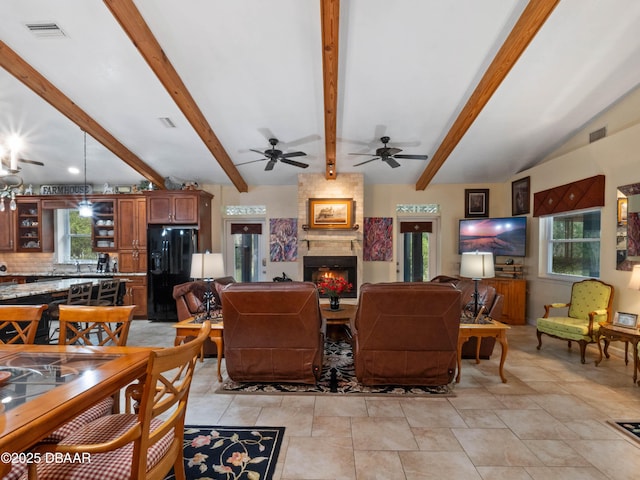 living room featuring a large fireplace, visible vents, and a healthy amount of sunlight