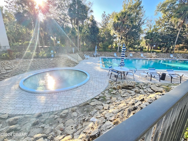 view of pool featuring a community hot tub and a patio area