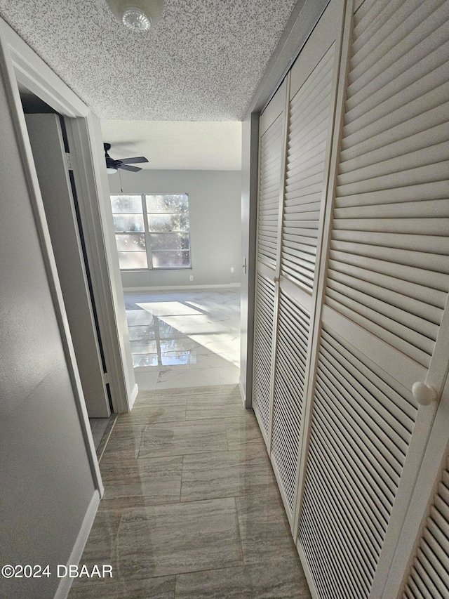 corridor featuring a textured ceiling