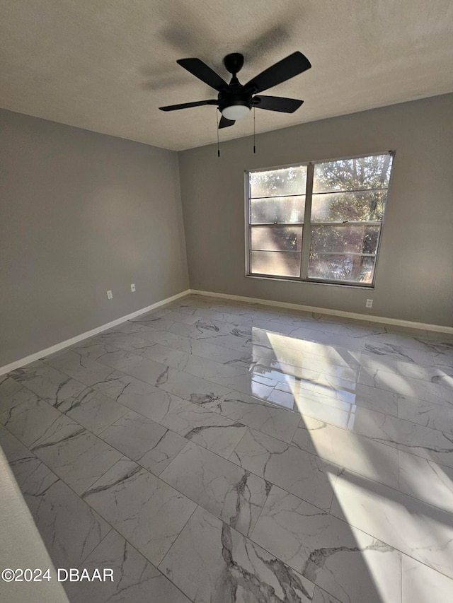 spare room with a textured ceiling and ceiling fan