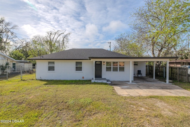 rear view of house featuring a carport and a lawn