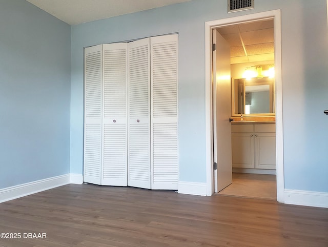 100 Silver Beach Ave Unit 308, Daytona Beach, FL 32118 - unfurnished bedroom with baseboards, wood finished floors, visible vents, and a closet
