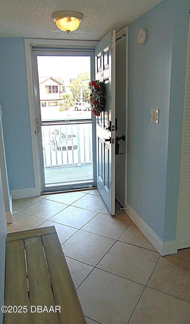 100 Silver Beach Ave Unit 308, Daytona Beach, FL 32118 - entryway with baseboards, light tile patterned flooring, and a textured ceiling