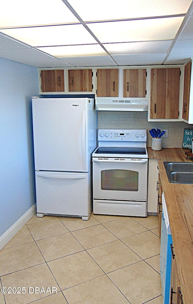 100 Silver Beach Ave Unit 308, Daytona Beach, FL 32118 - kitchen with under cabinet range hood, light tile patterned floors, a sink, white appliances, and baseboards