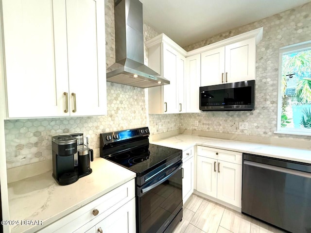 kitchen with white cabinets, decorative backsplash, wall chimney exhaust hood, light hardwood / wood-style flooring, and appliances with stainless steel finishes