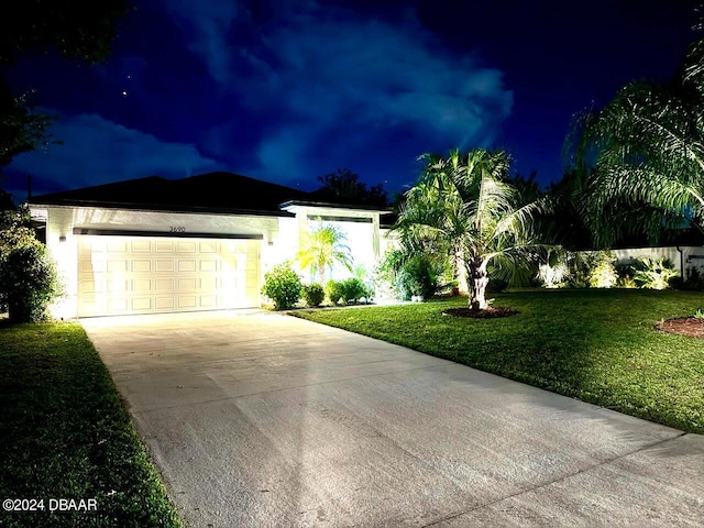 single story home featuring a garage and a yard