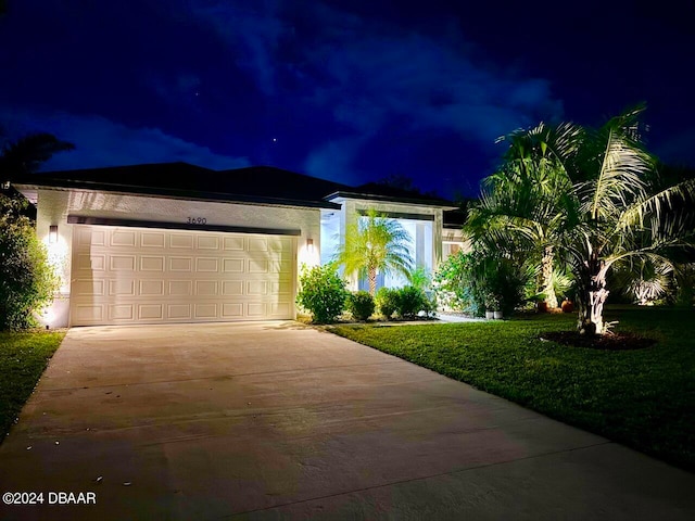 view of front of property with a lawn and a garage