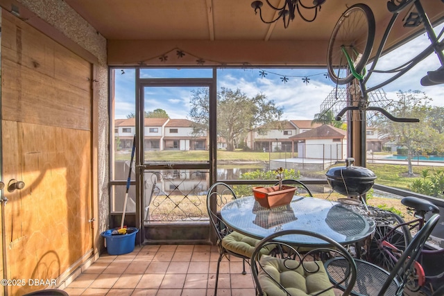 sunroom featuring plenty of natural light and a water view