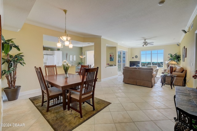 tiled dining space featuring ceiling fan with notable chandelier, a textured ceiling, and ornamental molding