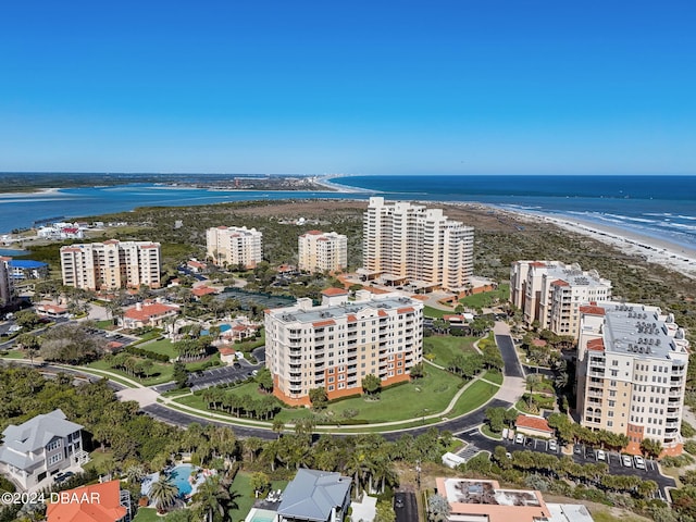 birds eye view of property with a water view and a beach view