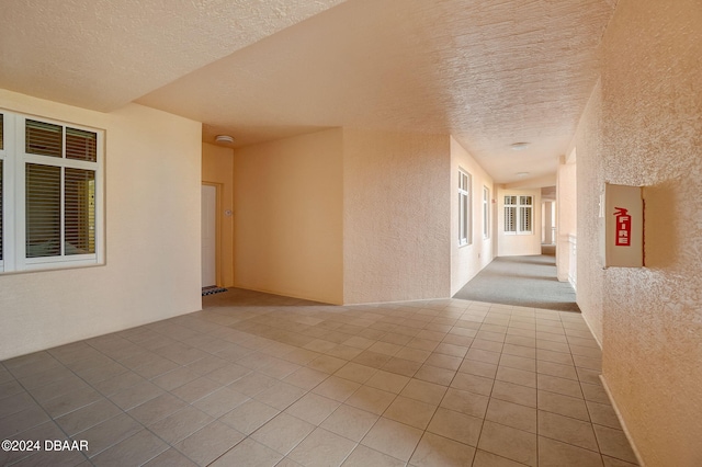 interior space featuring a textured ceiling and light tile patterned flooring