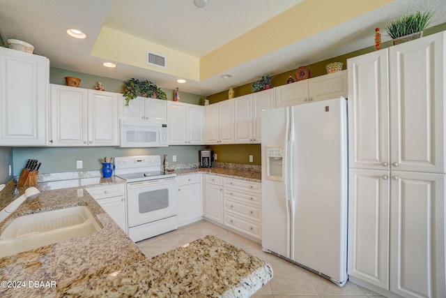 kitchen featuring white cabinets, a textured ceiling, sink, light tile patterned flooring, and white appliances