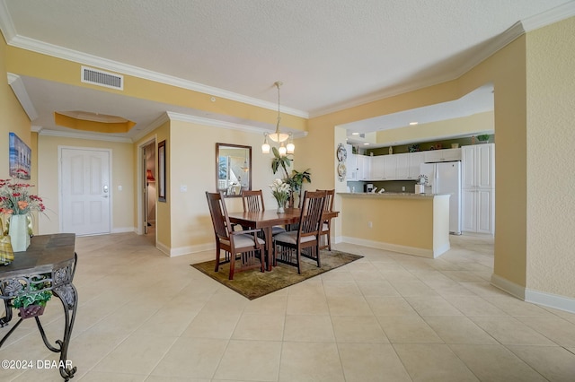 tiled dining space featuring ornamental molding, a notable chandelier, and a textured ceiling