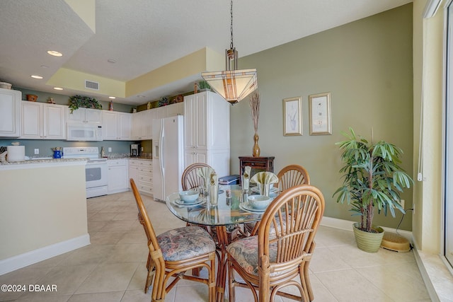 tiled dining room with a textured ceiling