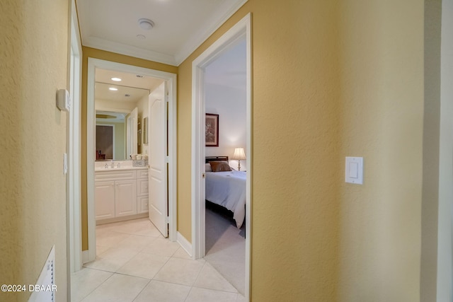 corridor with sink, light tile patterned floors, and ornamental molding