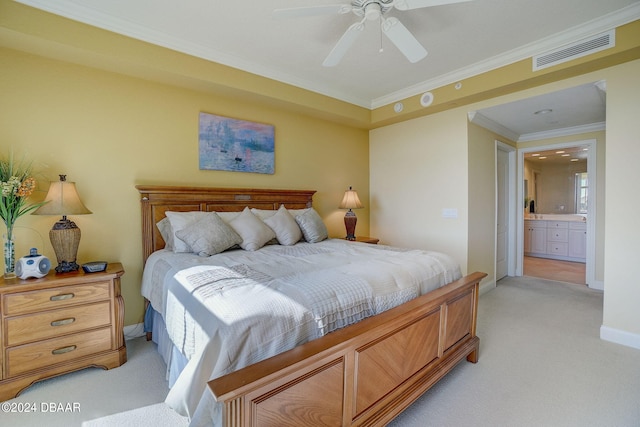 bedroom featuring ornamental molding, ensuite bath, light carpet, and ceiling fan