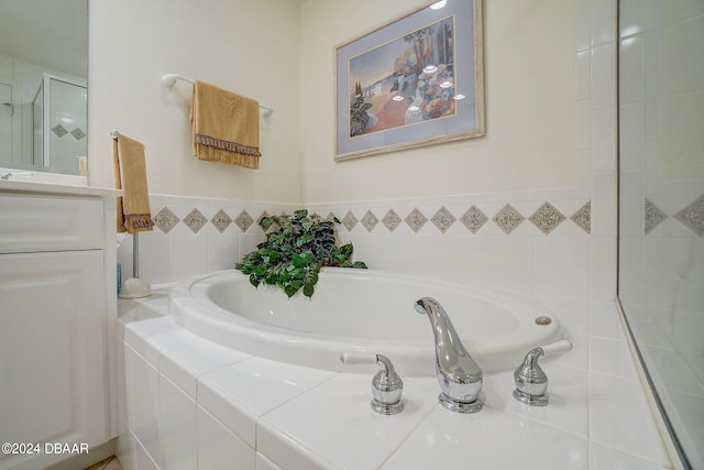 bathroom featuring vanity and a relaxing tiled tub