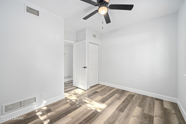 empty room with visible vents, baseboards, and wood finished floors