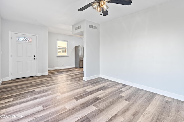 unfurnished room featuring wood finished floors, visible vents, and baseboards