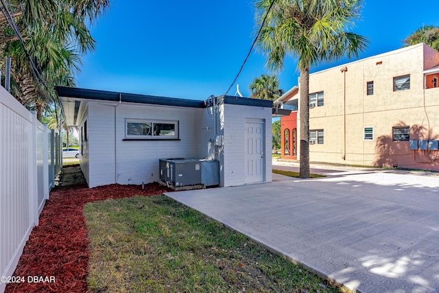 rear view of house featuring central AC unit and fence