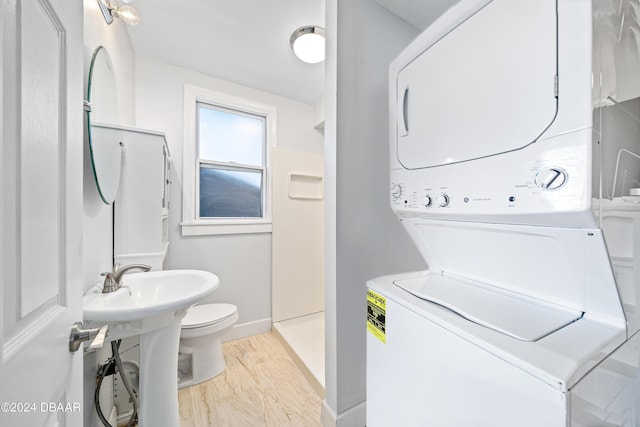 laundry room featuring baseboards, laundry area, and stacked washer / dryer