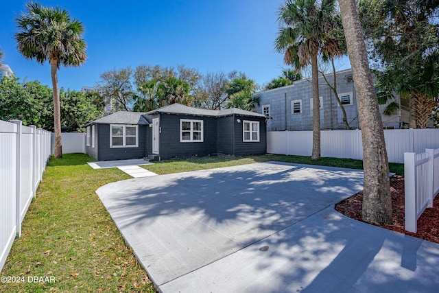 view of front of property with a front lawn, a fenced backyard, and a patio area