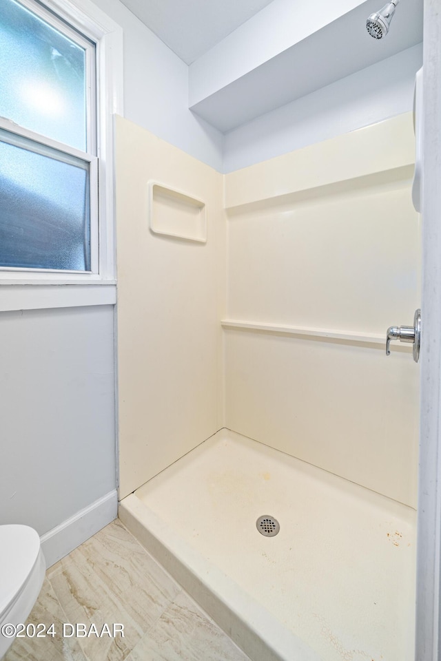 full bath featuring a shower stall, toilet, and baseboards