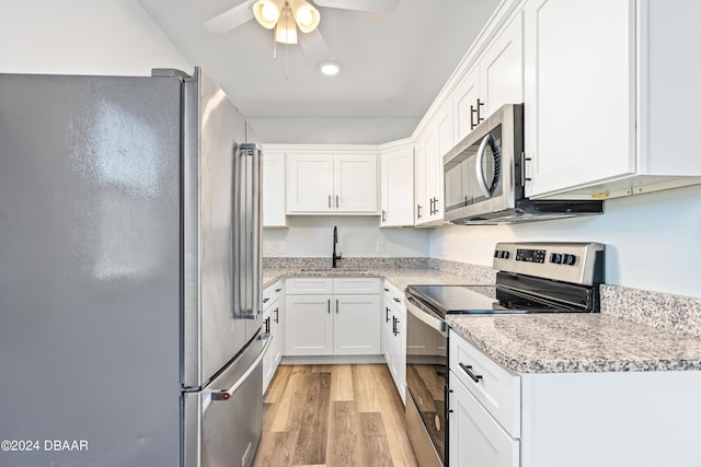 kitchen featuring a sink, white cabinets, light wood-style floors, and stainless steel appliances