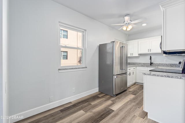 kitchen with white cabinetry, baseboards, high end fridge, and range with electric stovetop