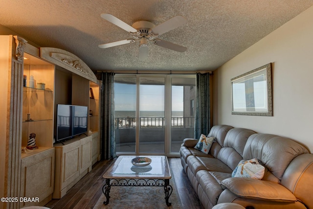 living room with ceiling fan, dark hardwood / wood-style floors, and a textured ceiling