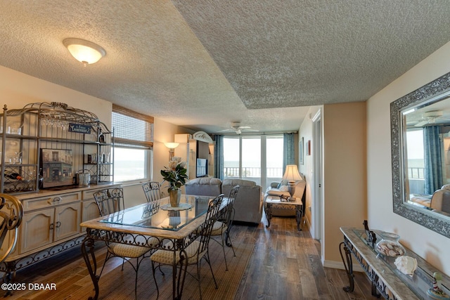 dining area with ceiling fan, a textured ceiling, dark wood-type flooring, and a healthy amount of sunlight