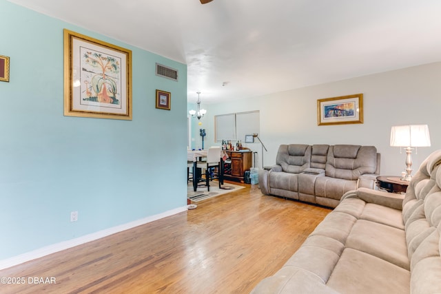 living room featuring a chandelier and light hardwood / wood-style flooring