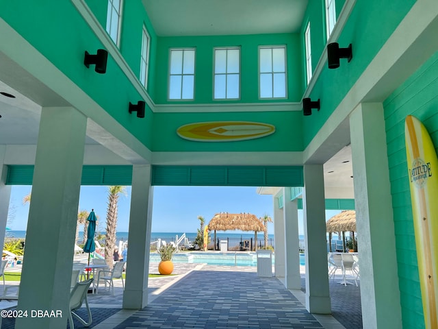 view of patio with a community pool and a water view