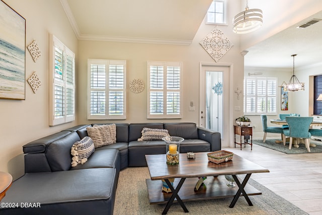 living room featuring ornamental molding, light hardwood / wood-style flooring, and an inviting chandelier