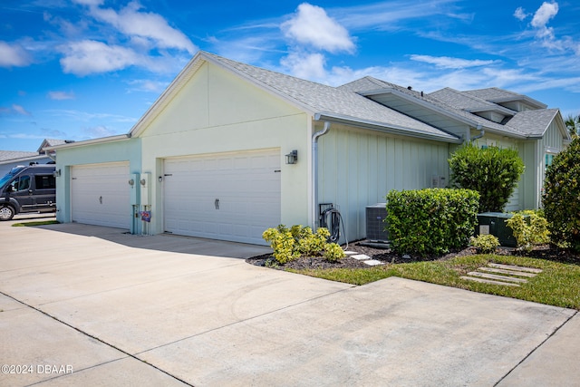 view of home's exterior with central AC unit and a garage