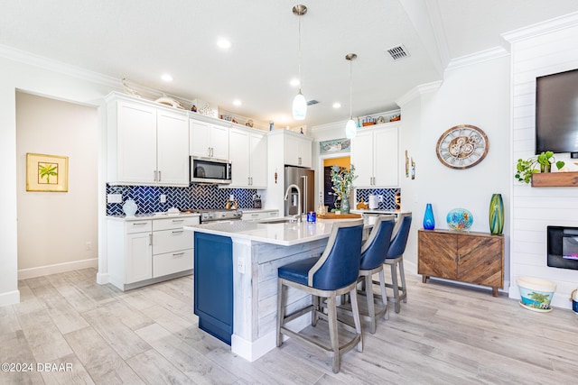 kitchen featuring high end appliances, white cabinets, and decorative light fixtures