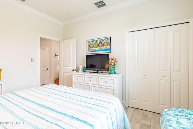 bedroom featuring a closet, crown molding, and light hardwood / wood-style flooring