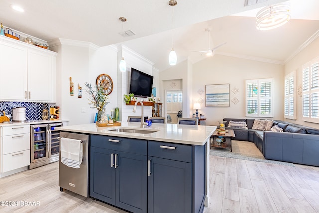 kitchen featuring lofted ceiling, white cabinets, sink, pendant lighting, and wine cooler