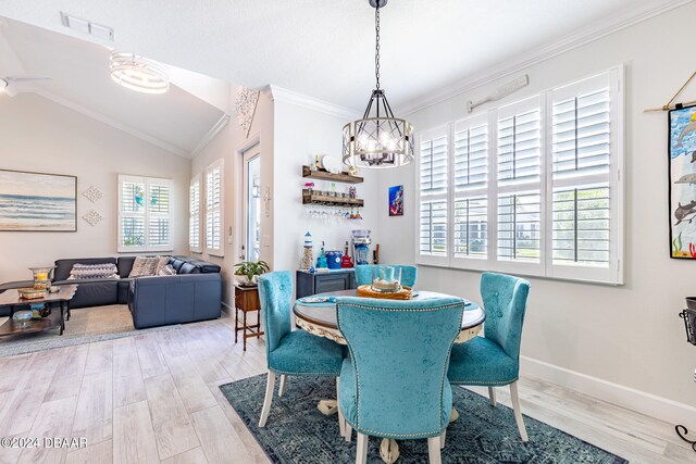 dining space featuring vaulted ceiling, a chandelier, light hardwood / wood-style flooring, and crown molding