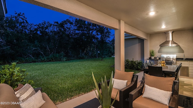 yard at night featuring a patio, exterior kitchen, and sink