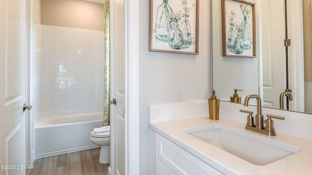 full bathroom with shower / bath combination, wood-type flooring, toilet, and vanity