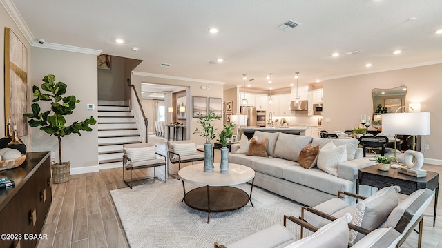 living room with light hardwood / wood-style floors and crown molding